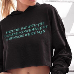 Empowering black feminist hoodie with the message 'Seize the Day with the Unearned Confidence of a Mediocre White Man,' advocating for confidence and equality. Discover feminist apparel