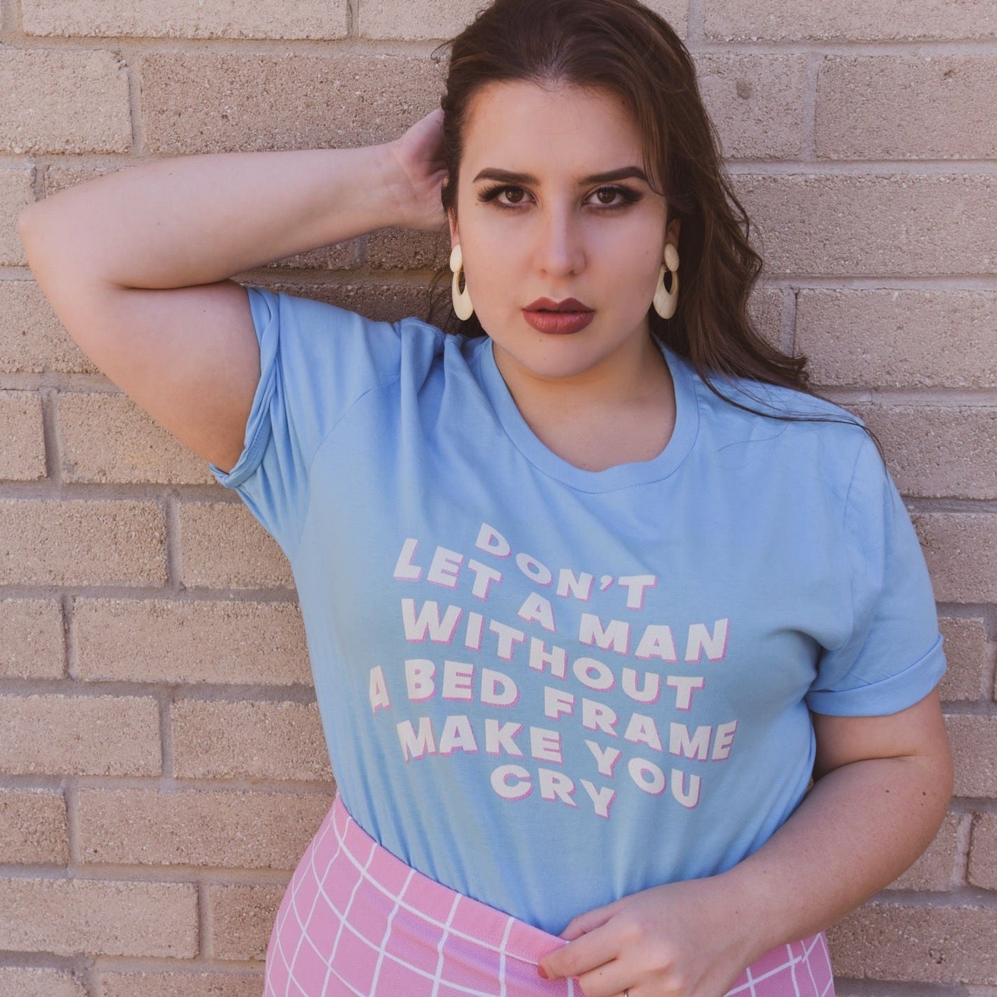 Ocean blue feminist t shirt boldly stating "Don't Let a Man Without a Bed Frame Make You Cry."