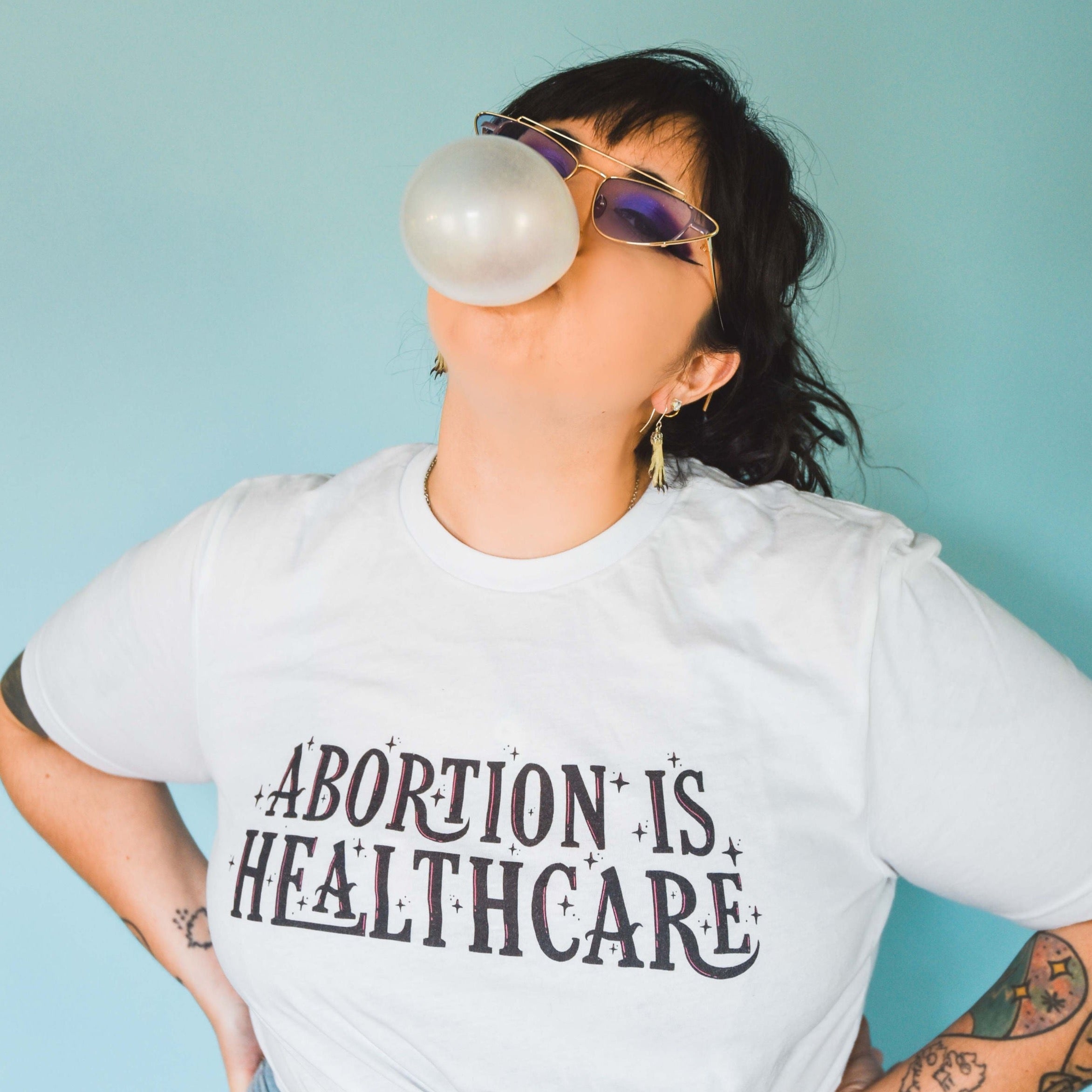 Feminist t-shirt in white advocating 'Abortion is Healthcare' and women’s rights