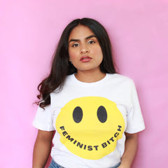 White feminist t-shirt conveying: "Feminist Bitch" with a yellow smiley face
