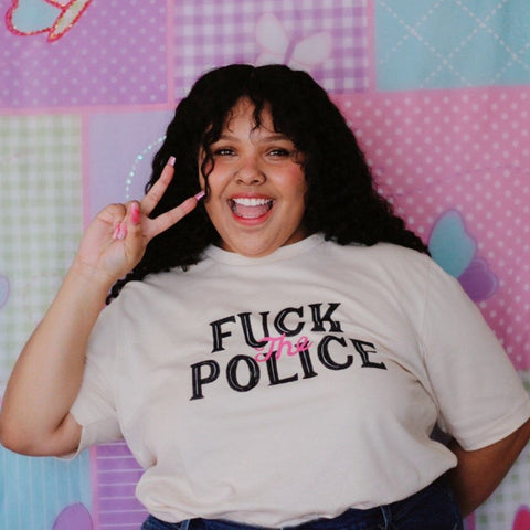 White feminist t shirt boldly featuring "Fuck the Police" in black and pink writing