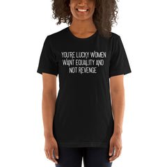 A smiling person wearing the black "You’re Lucky Women Want Equality And Not Revenge" graphic tee. Styled as a casual activist outfit, showcasing the fit and scale of the Feminist Trash apparel line.