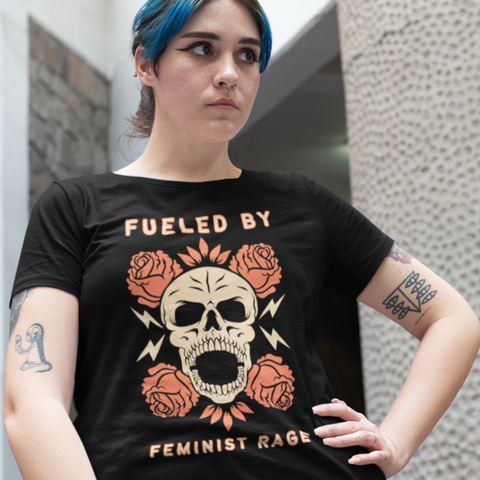 black feminist tee that says fueled by feminist rage in beige and orange writing- featuring a screaming skull surrounded by roses. shop feminist trash for witchy outfits and feminist tees