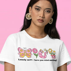 white feminist tee making fun of the self inflicted male loneliness epidemic. Lonely men... have you tried smiling? Featuring cute pink illustrations of a worm, flowers and a butterfly. Shop Feminist Trash for funny t-shirts for women and feminist tees