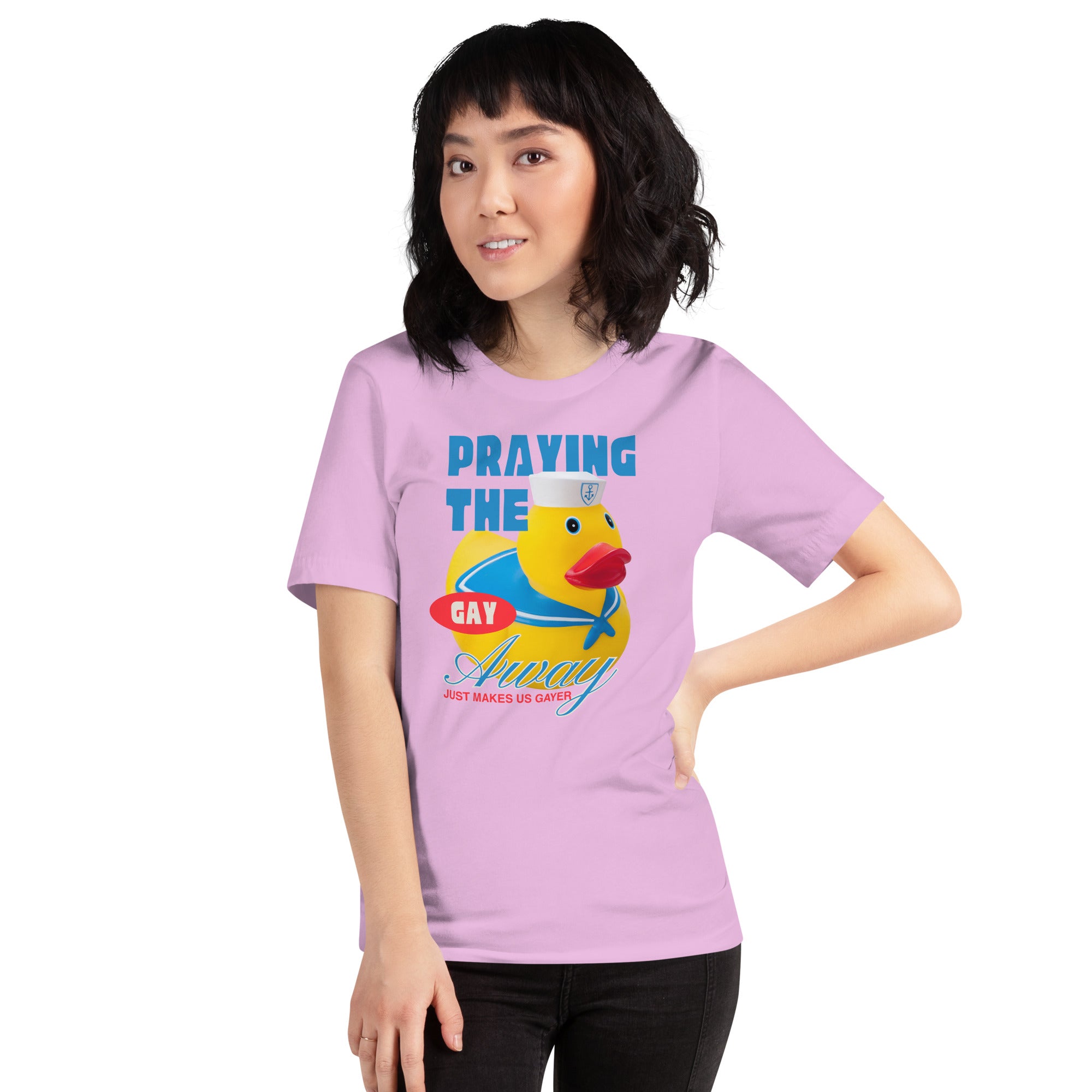 A model with dark wavy hair smiling while posing with a hand on her hip wearing the lilac Feminist Trash t shirt with the slogan praying the gay away just makes us gayer