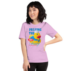 A model with dark wavy hair smiling while posing with a hand on her hip wearing the lilac Feminist Trash t shirt with the slogan praying the gay away just makes us gayer