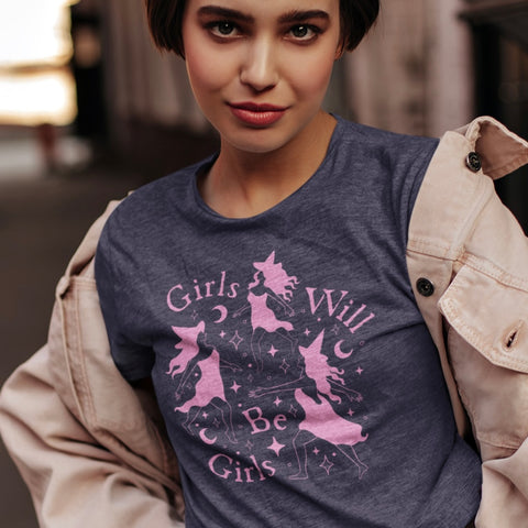 witchy feminist t shirt that says girls will be girls in pink- featuring dancing witch illustration- shop feminist trash for witchy outfits and feminist tees.