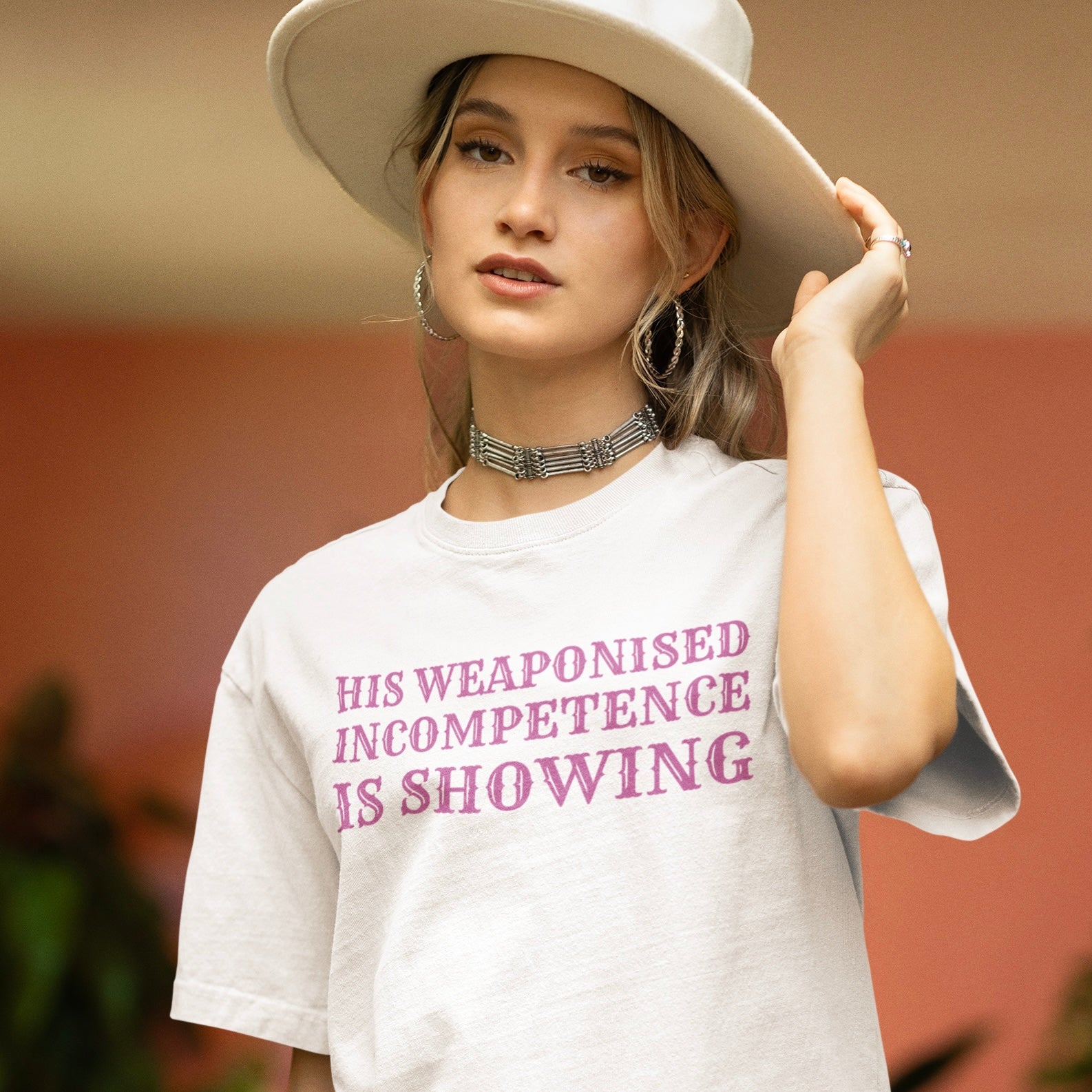 white feminist shirt that says his weaponised incompetence is showing in purple western style writing- shop feminist trash for feminist clothing and women's march merchandise