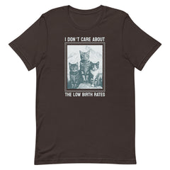 Flat lay of a chocolate brown t-shirt from Feminist Trash featuring three cats and the text "I DON'T CARE ABOUT THE LOW BIRTH RATES." A satirical feminist graphic tee.