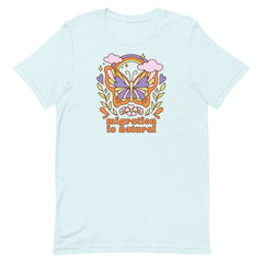 Pale blue short sleeve tee with a whimsical butterfly and rainbow design promoting the message migration is natural in a vintage dopamine decor style.