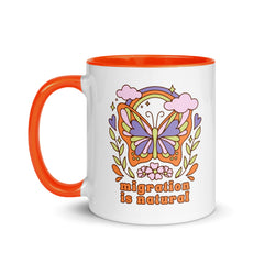 A white ceramic mug with an orange handle and rim featuring a retro butterfly graphic and the text "Migration is Natural." Shop Feminist Trash for political mugs