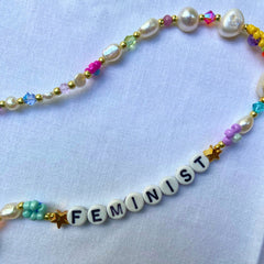 Pearl and seed bead feminist beaded necklace featuring and array of colourful beads. Shop feminist jewellery for empowered women.