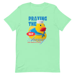 A mint green soft cotton unisex pride t shirt featuring a campy yellow rubber duck sailor graphic with the satirical phrase praying the gay away just makes us gayer