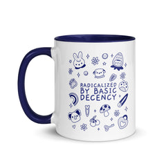 A high-quality ceramic coffee mug featuring the text "Radicalized by Basic Decency" in bold typography. The mug features a contrasting colorful handle and interior, displayed against a clean white background.