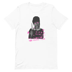 A flat lay view of a premium white unisex cotton political shirt displaying a high-contrast black-and-white portrait graphic accented with bright pink stars, a knife, and punk rock zine typography reading "Your God Wants You to Sacrifice the Trillionaire."