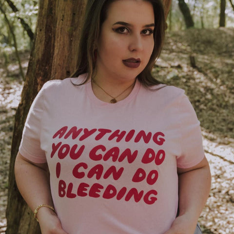 Monochromatic pink feminist t-shirt with 'Anything You Can Do I Can Do Bleeding' typography. A cute coquette-activist style shirt for challenging menstrual taboos- shop Feminist Apparel 