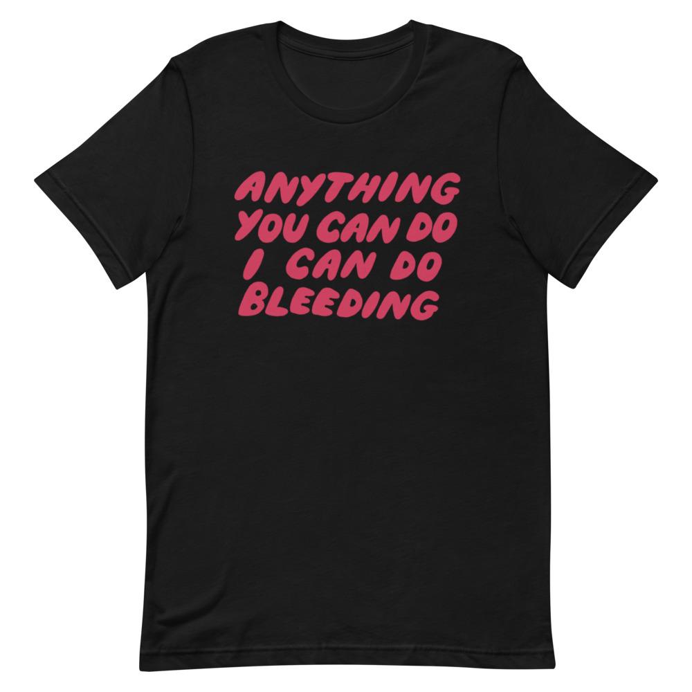 Black unisex t-shirt featuring hand-lettered pink text that reads 'Anything You Can Do I Can Do Bleeding'. High-contrast social justice apparel from Feminist Trash.