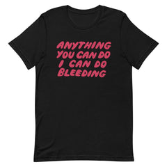 Black unisex t-shirt featuring hand-lettered pink text that reads 'Anything You Can Do I Can Do Bleeding'. High-contrast social justice apparel from Feminist Trash.