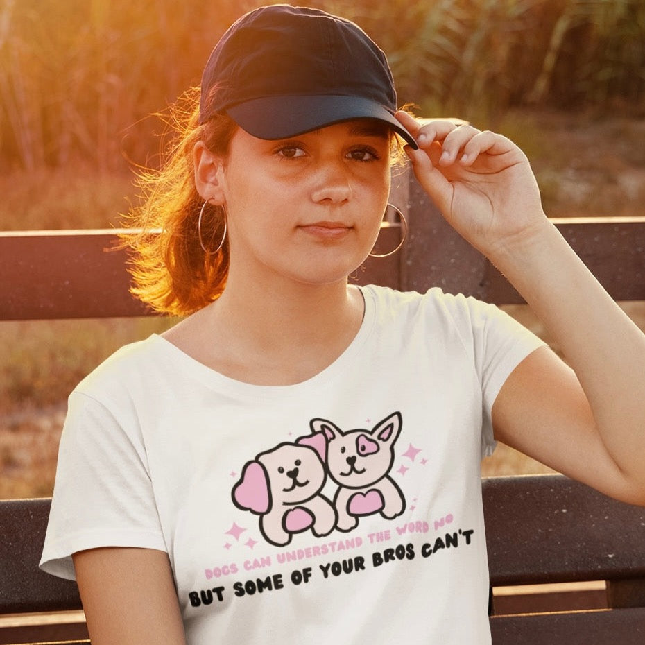 White feminist tee that says Dogs Can Understand The Word No But Some Of Your Bros Can’t in pink and black writing featuring a cute illustration of two dogs. Shop Women’s Rights T-shirts and feminist clothing.