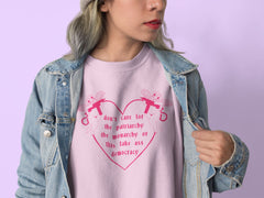 pink feminist sweatshirt that says Don’t Care For The Patriarchy, The Monarchy Or This Fake Ass Democracy in red writing surrounded by angel cherubs holding guns- shop feminist sweatshirts and dump him shirts