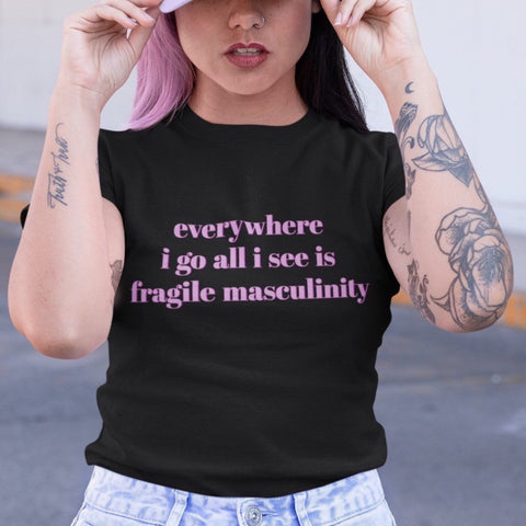 black feminist tee that says Everywhere I Go All I See Is Fragile Masculinity in purple lowercase font. Shop Feminist Trash for feminist tshirts, political clothing, ACAB shirts, Witchy outfits and dump him shirts