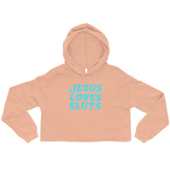 Peach coloured Jesus Loves Sluts Crop Feminist Hoodie With Bold Blue Writing- Shop feminist apparel and dump him shirts
