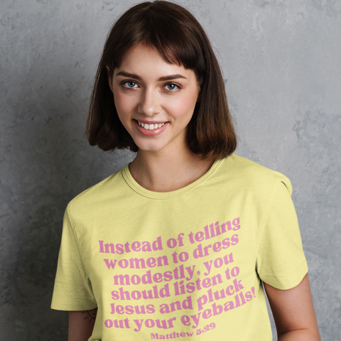 yellow feminist t-shirt that says instead of telling women to dress modestly, you should listen to jesus and pluck out your eyeballs! In pink writing- shop feminist trash for women's march merchandise and funny feminist clothing